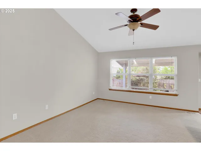 a view of a livingroom with a ceiling fan and window