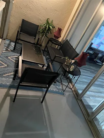 a living room with chairs and wooden floor