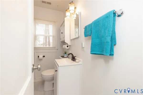 a bathroom with a sink vanity mirror and toilet