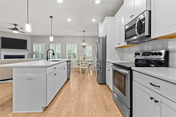 a kitchen with stainless steel appliances granite countertop a sink a stove top oven a counter space and cabinets