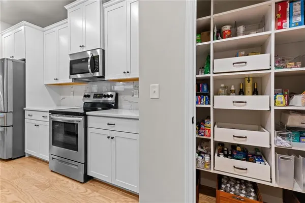 a kitchen with stainless steel appliances granite countertop a refrigerator and a stove