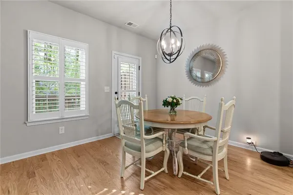 a view of a dining room with furniture a chandelier and wooden floor