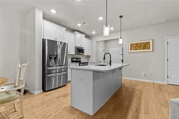 a kitchen with refrigerator cabinets and wooden floor