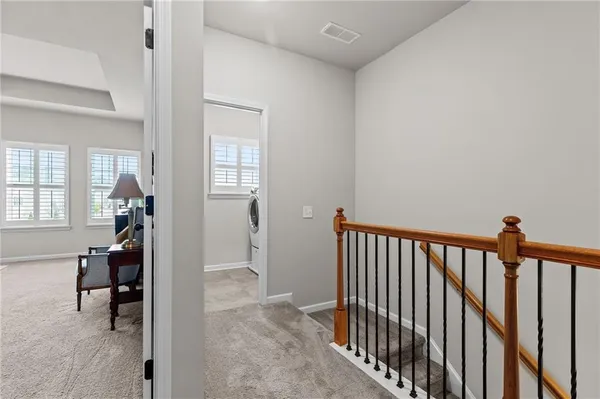 a view of a hallway to a livingroom with furniture