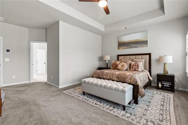 a bedroom with a bed lamp on table and a window