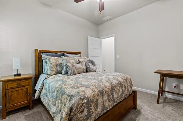 a large bed sitting in a bedroom next to a window with a chair
