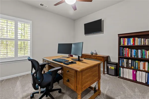 a view of a workspace with furniture and a bookshelf