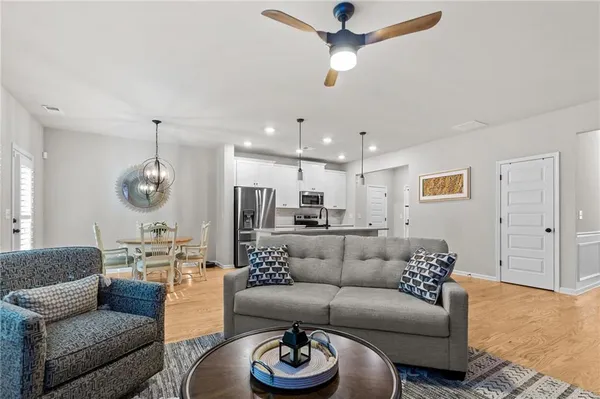 a living room with furniture kitchen view and a chandelier
