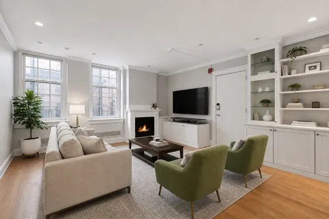 a living room with furniture a flat screen tv and a fireplace