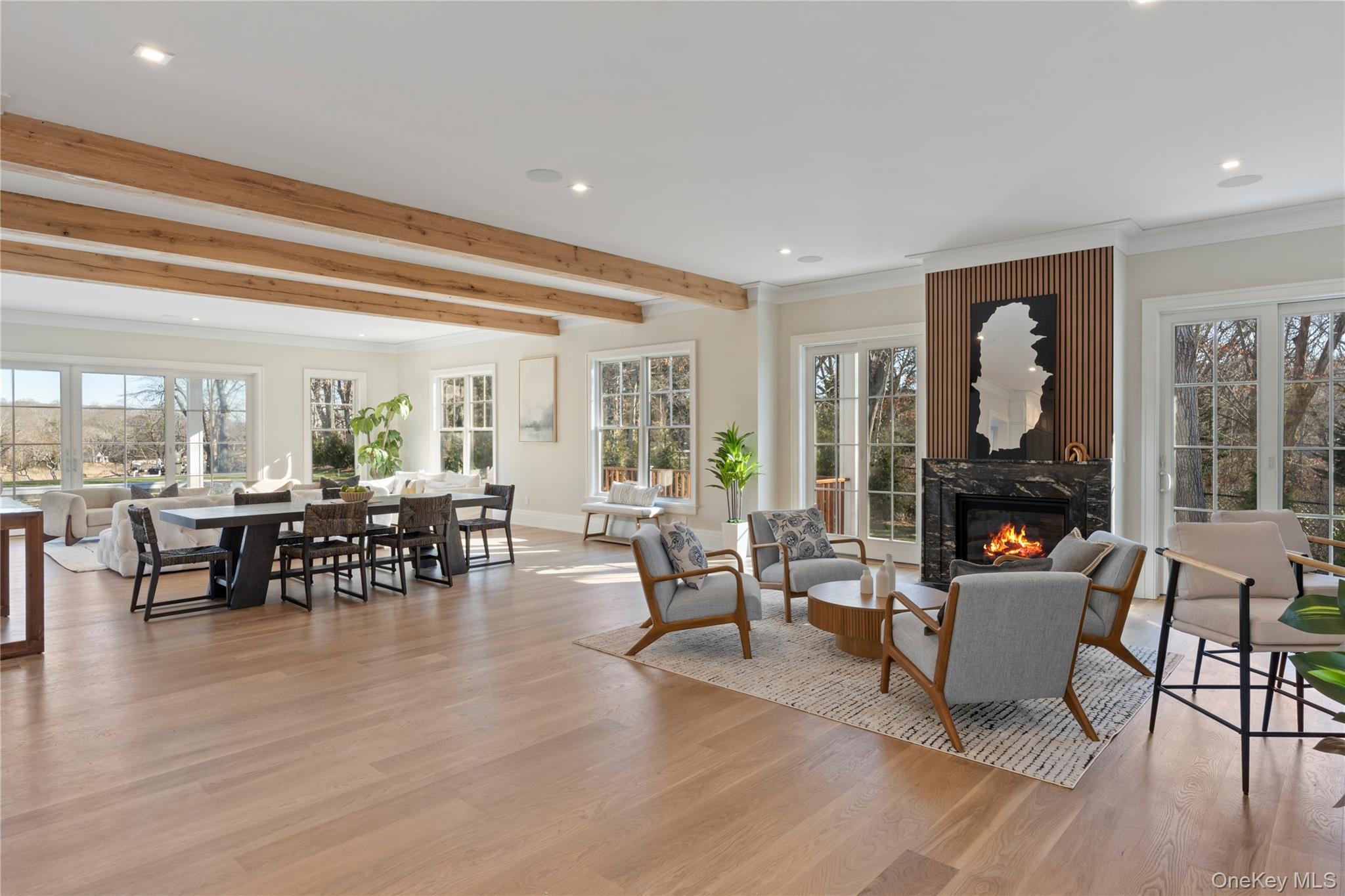 2590 Cox Neck Road Mattituck, NY 11952 - Photo 5 of 50 A dramatic great room with soaring ceilings, wide plank white oak floors, and walls windows framing panoramic waterfront vistas