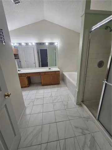 a bathroom with a tub a mirror and shower