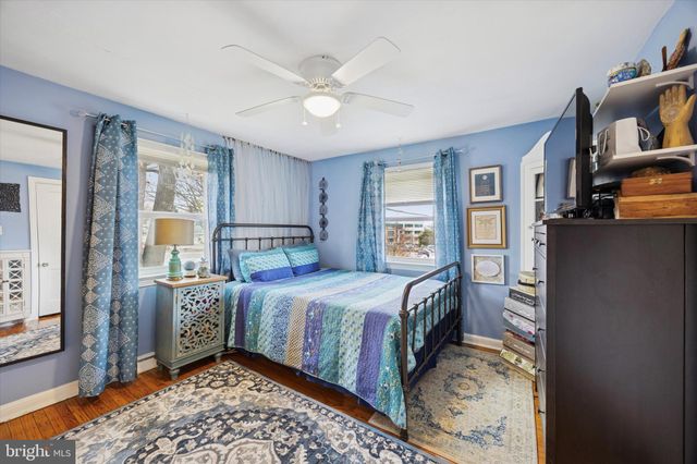 a bedroom with a bed and large windows