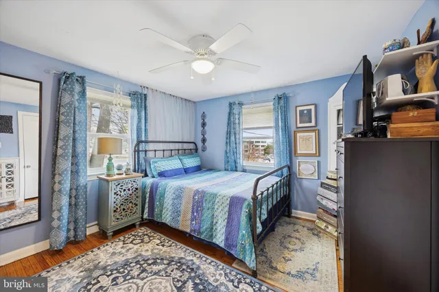 a bedroom with a bed and large windows