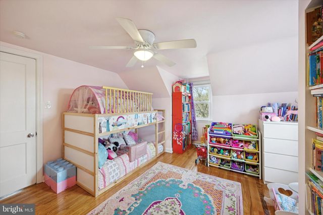 a bedroom with baby crib and wooden floor