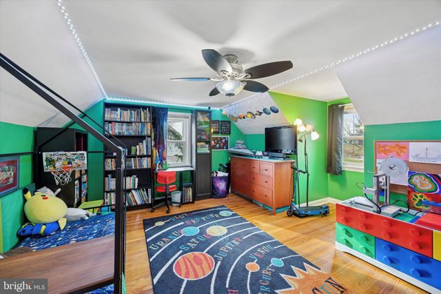 a bedroom with a bed bookshelf and a window