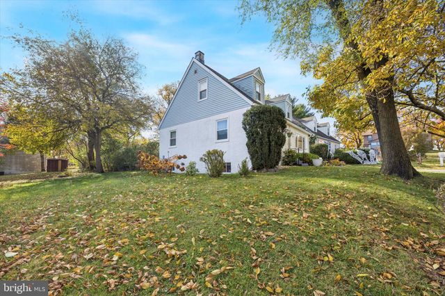 a view of a house with backyard and trees