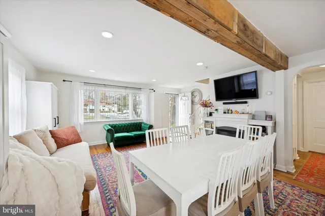 a living room with furniture a flat screen tv and a large window