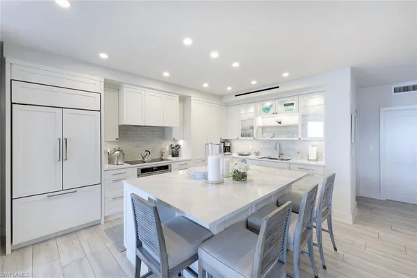 a kitchen with a dining table chairs and refrigerator