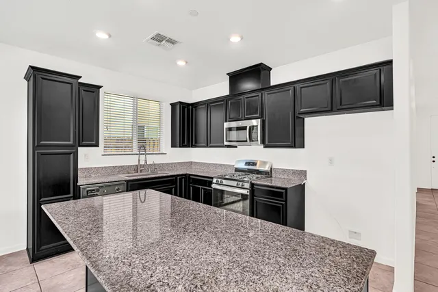 a kitchen with granite countertop a sink and a wooden floor