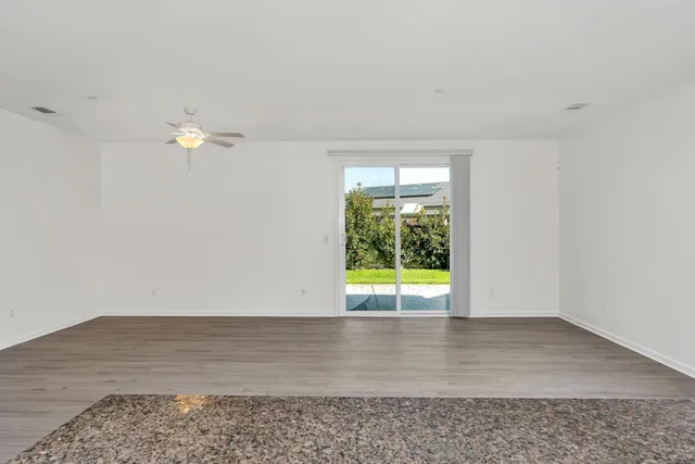 a large kitchen with stainless steel appliances granite countertop a large counter top and a stove with wooden floor