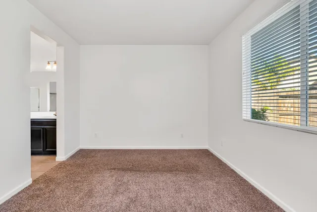 a view of a yard with an empty space and wooden fence