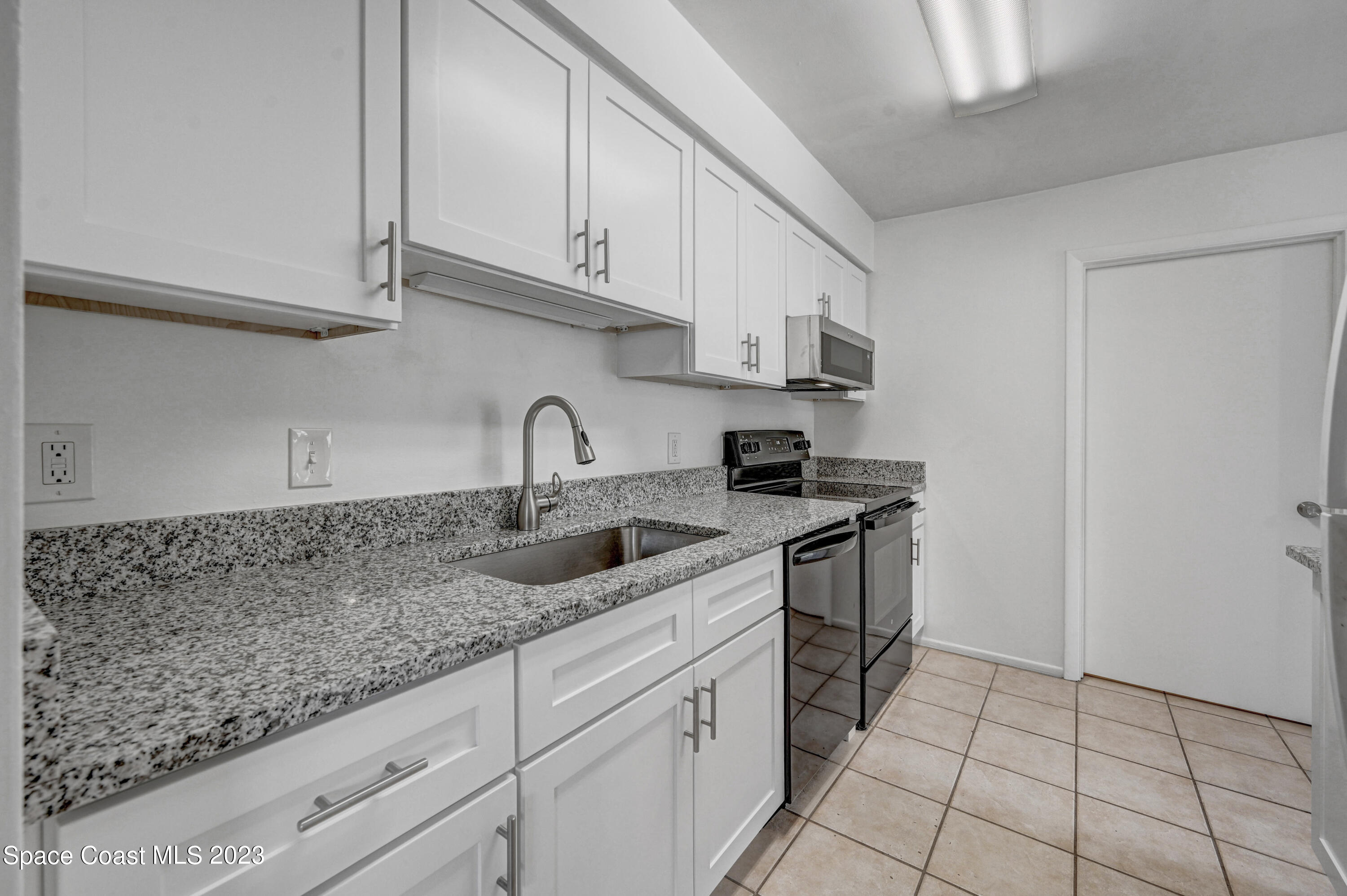 2781 Hereford Road Melbourne, FL 32935 - Photo 16 of 33 a kitchen with stainless steel appliances granite countertop a sink stove and cabinets