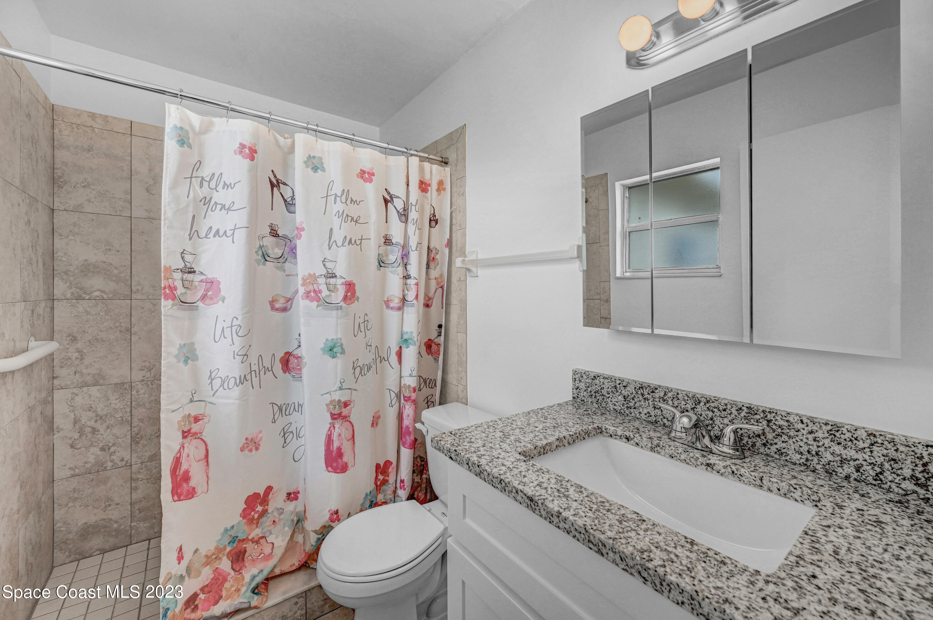 2781 Hereford Road Melbourne, FL 32935 - Photo 22 of 33 a bathroom with a sink a toilet and shower curtain