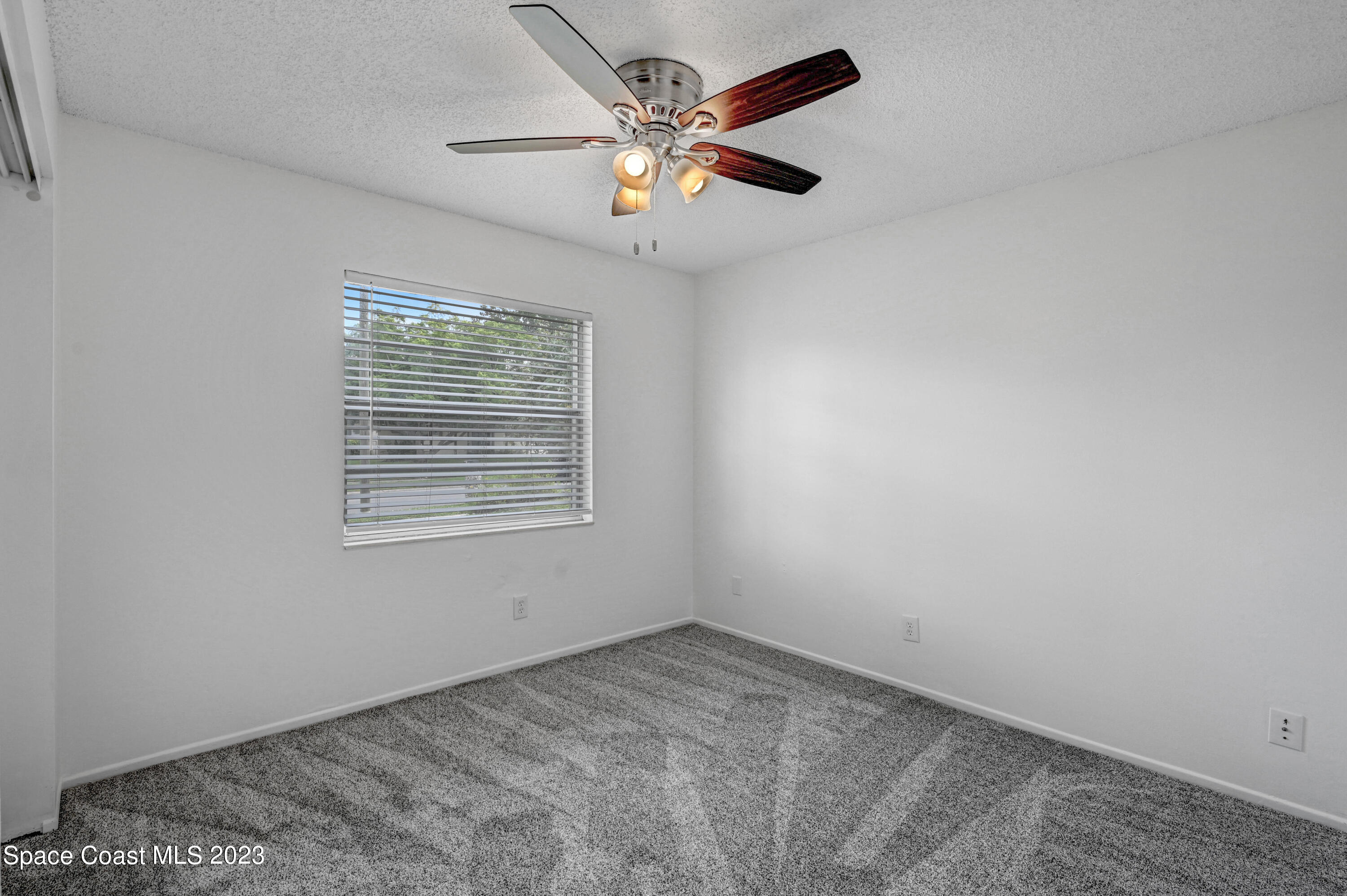 2781 Hereford Road Melbourne, FL 32935 - Photo 23 of 33 an empty room with ceiling fan and window