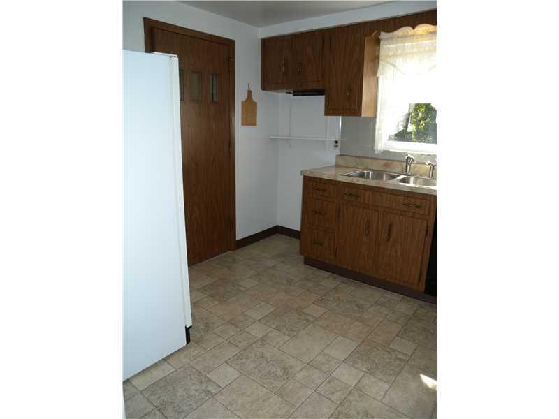 1104 Brinton Road Braddock Hills, PA 15221 - Photo 6 of 20 Kitchen. Vinyl flooring in remarkable condition~Well-maintained cabinetry~Additional space for storage shelves, prep table~Door leads to one-car integral garage~