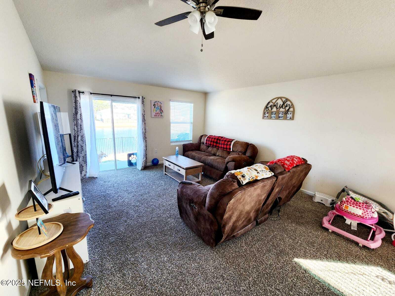 2432 Falling Star Ln Green Cove Springs Green Cove Springs, FL 32043 - Photo 18 of 24 a living room with furniture a window and a flat screen tv