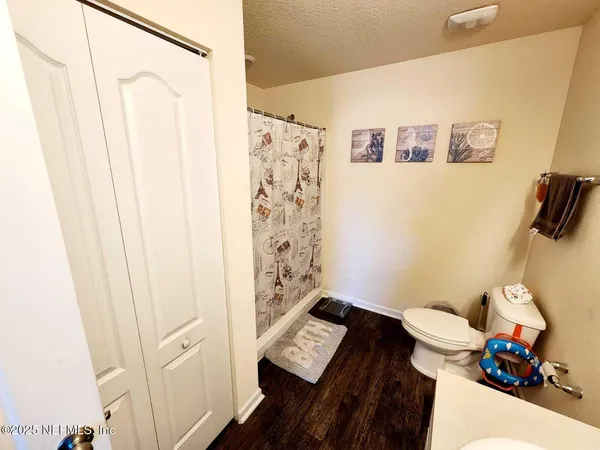 a bathroom with a toilet and a shower curtain