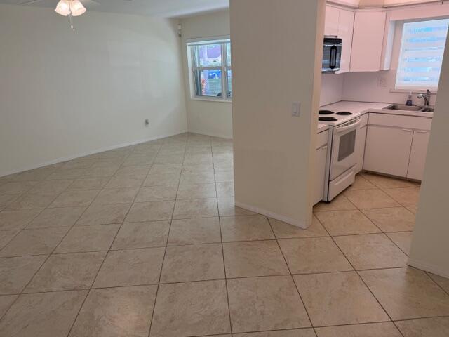 3801 Northeast 22nd Terrace, Unit 12 Lighthouse Point, FL 33064 - Photo 6 of 14 a kitchen with cabinets and a stove top oven