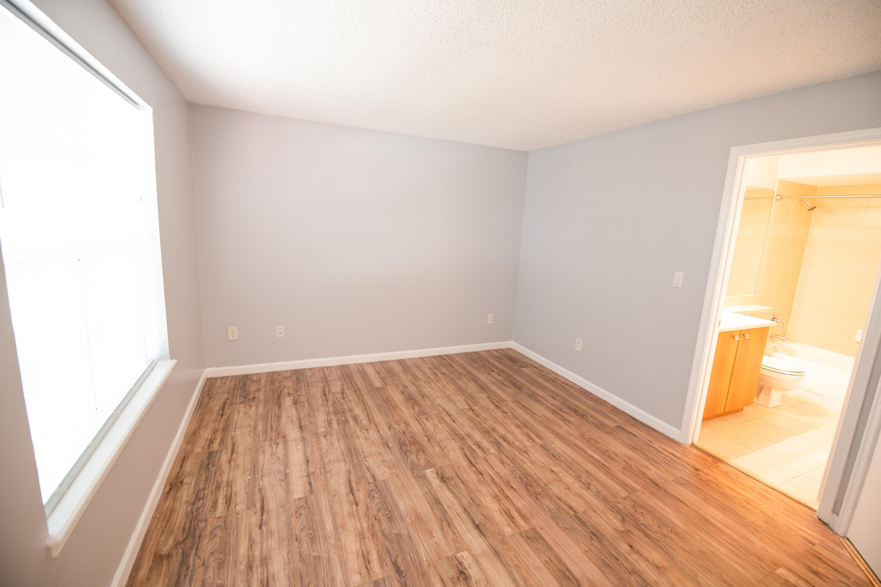 1165 Crystal Way, Unit B Delray Beach, FL 33444 - Photo 14 of 27 an empty room with wooden floor and windows