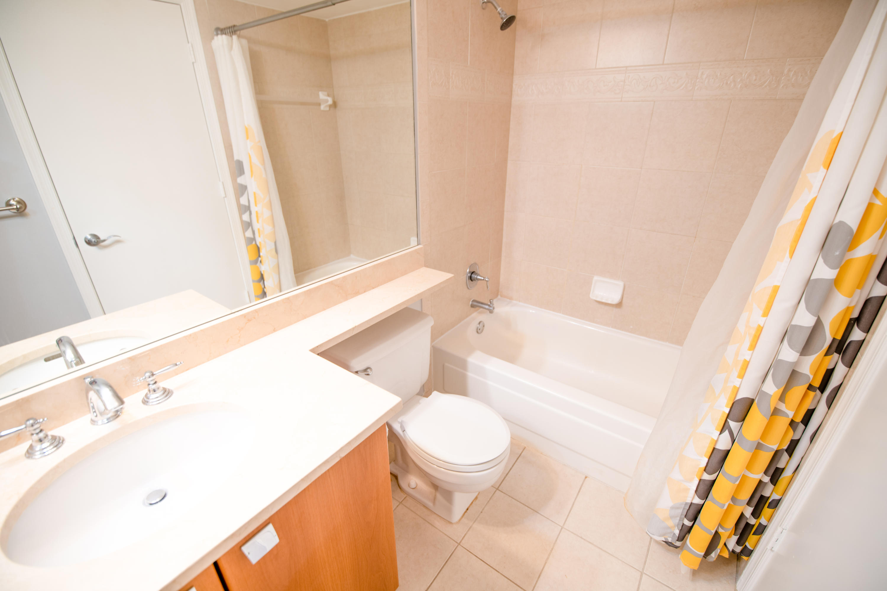 1165 Crystal Way, Unit B Delray Beach, FL 33444 - Photo 17 of 27 a bathroom with a sink a toilet and shower curtain