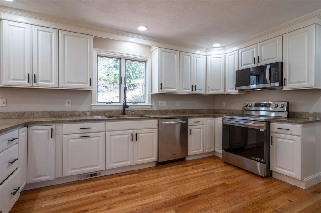 120 Bear Hill Road North Andover, MA 01845 - Photo 3 of 42 a kitchen with stainless steel appliances granite countertop a stove a sink and white cabinets