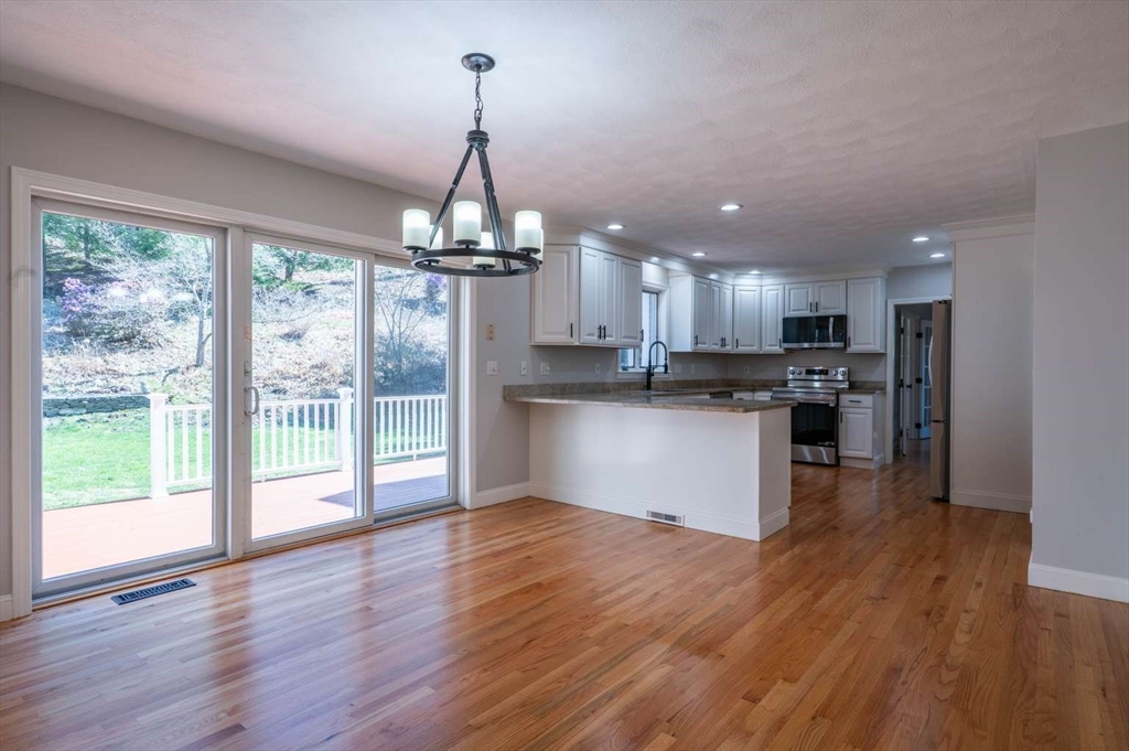 120 Bear Hill Road North Andover, MA 01845 - Photo 7 of 42 a view of a kitchen with a sink a refrigerator and wooden floor