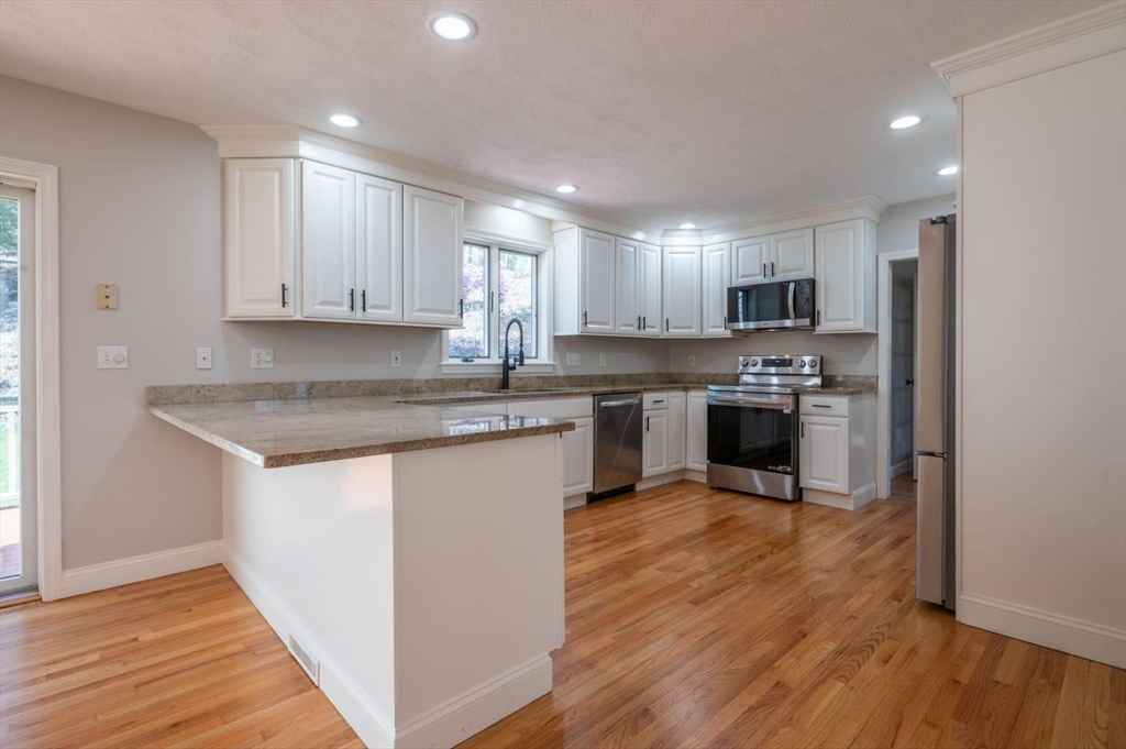 120 Bear Hill Road North Andover, MA 01845 - Photo 8 of 42 a kitchen with stainless steel appliances granite countertop a sink a stove a refrigerator and cabinets