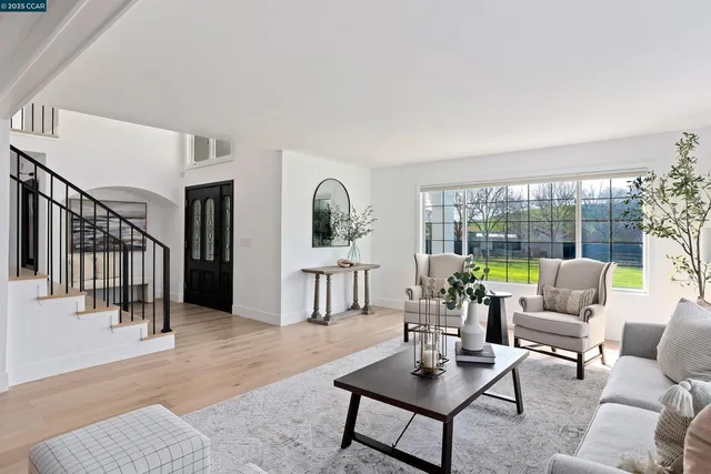 a kitchen with stainless steel appliances granite countertop a stove top oven a sink dishwasher a dining table and chairs with wooden floor