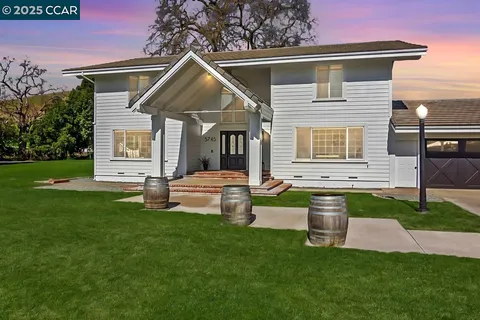 a front view of a house with a yard and fence