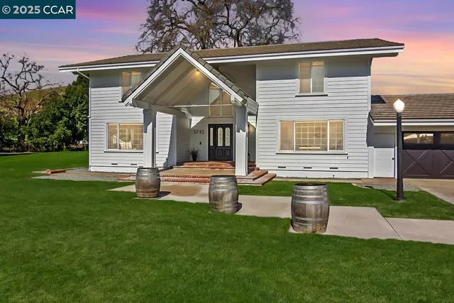 a front view of a house with a yard and fence