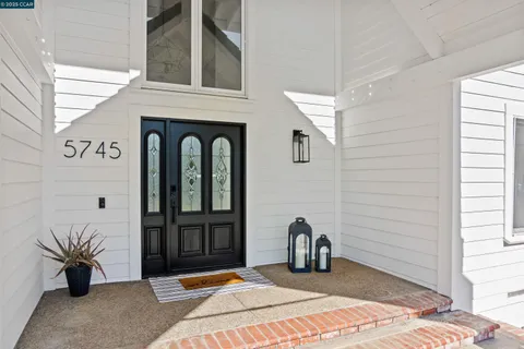 a living room with furniture large window and a table