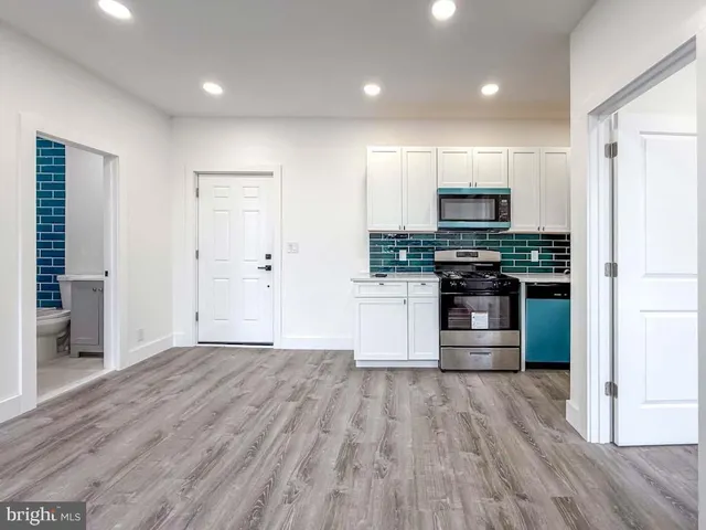 a kitchen with stainless steel appliances a refrigerator and a stove top oven