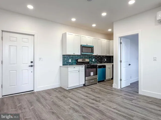 a kitchen with stainless steel appliances granite countertop a stove a refrigerator and a microwave