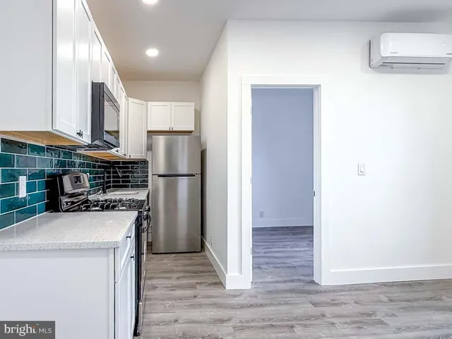 a view of a kitchen with wooden floor and electronic appliances