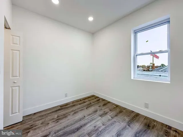 an empty room with wooden floor and closet