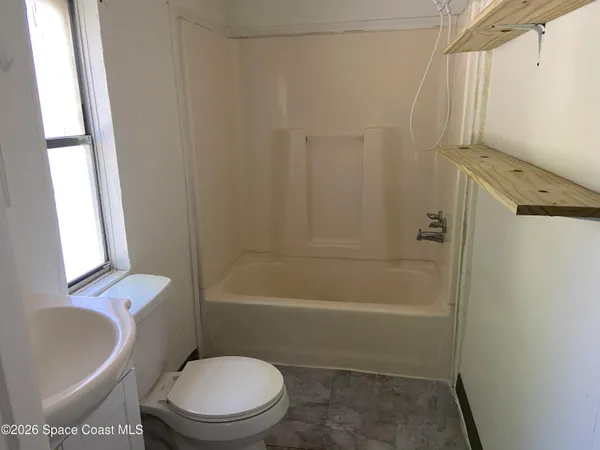 a white toilet sitting next to a white sink