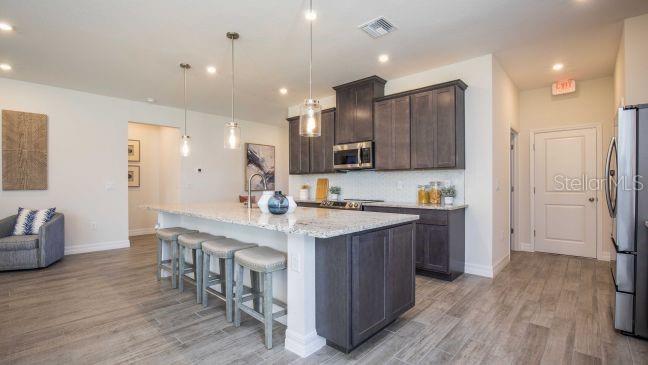 625 Bell Avenue Inverness, FL 34452 - Photo 4 of 17 a kitchen with stainless steel appliances granite countertop a table chairs refrigerator and a sink