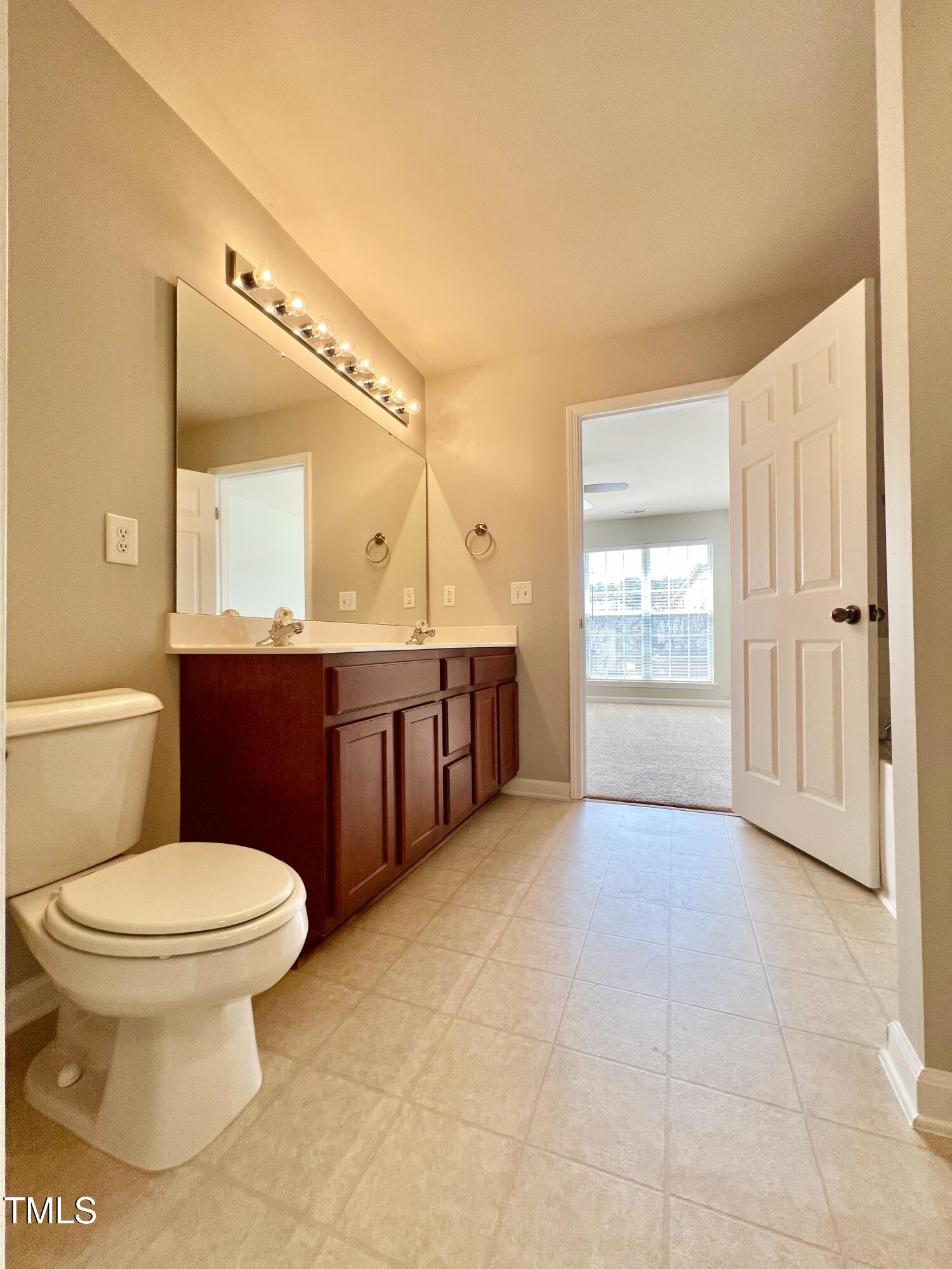 2118 Kedvale Avenue Raleigh, NC 27617 - Photo 14 of 17 a bathroom with a sink a toilet and mirror