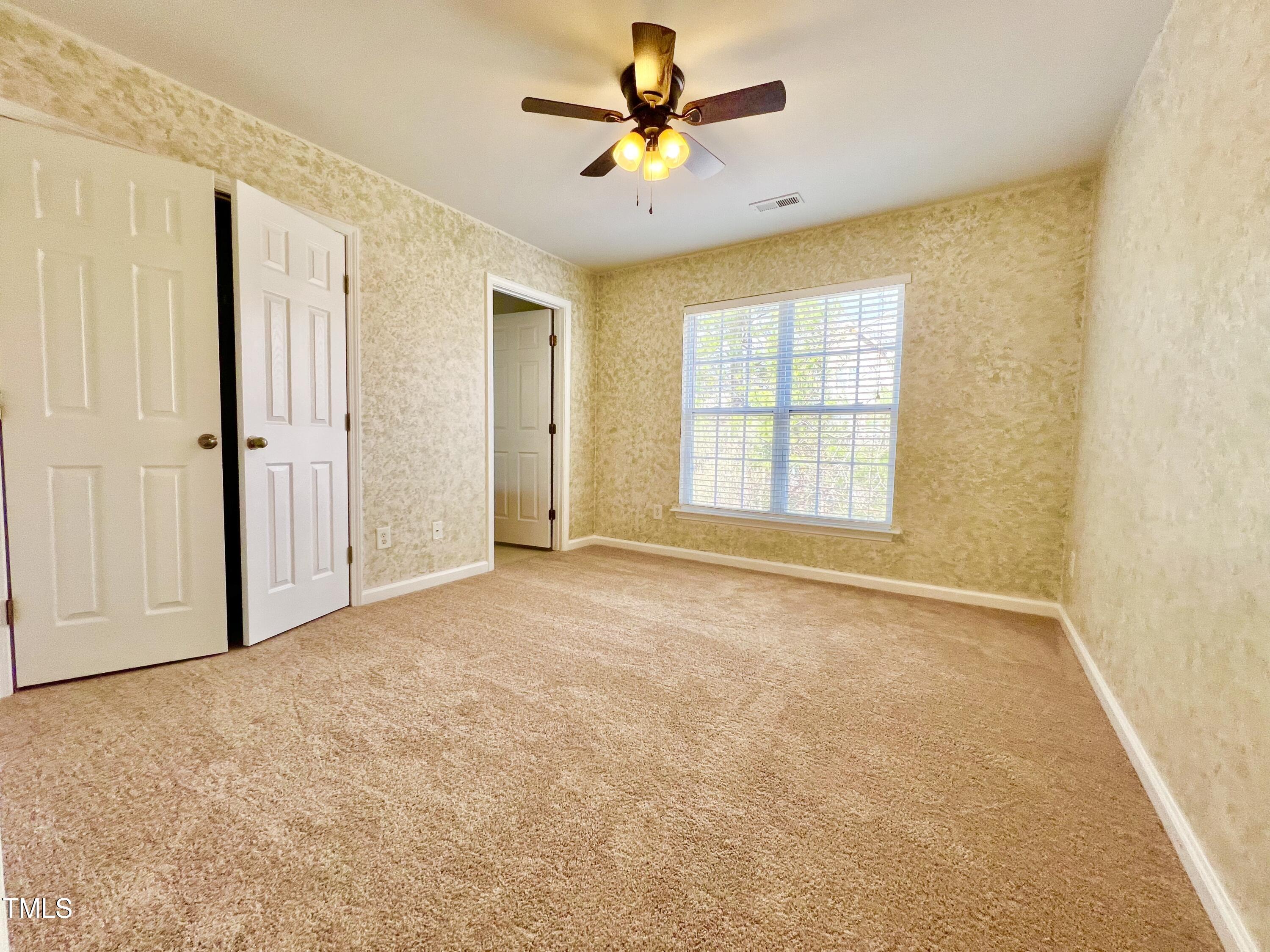 2118 Kedvale Avenue Raleigh, NC 27617 - Photo 17 of 17 an empty room with chandelier fan and windows