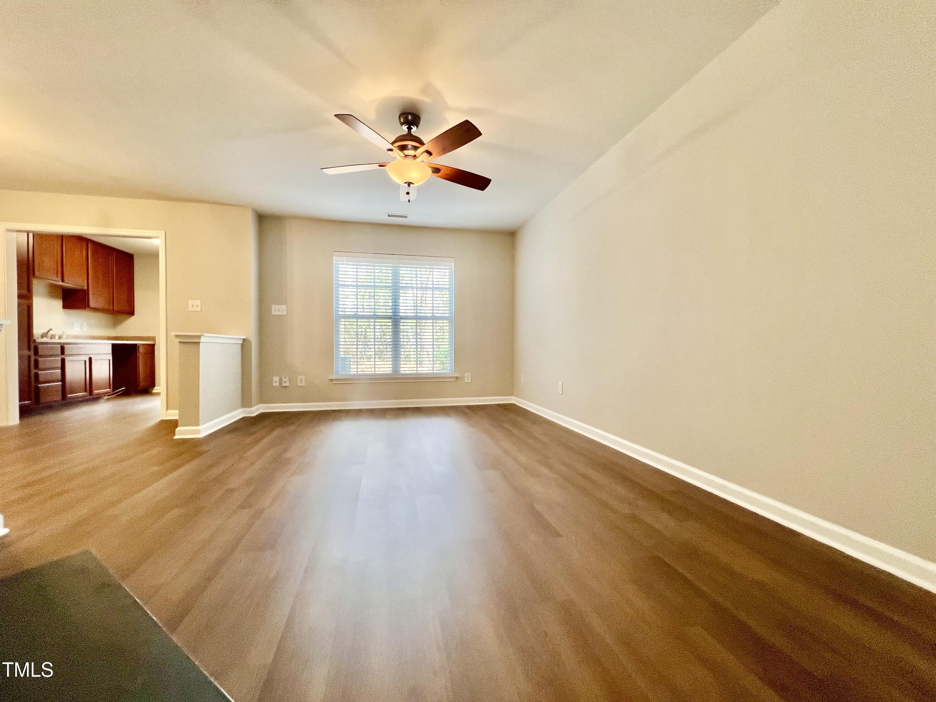 2118 Kedvale Avenue Raleigh, NC 27617 - Photo 3 of 17 a view of an empty room with wooden floor and fan